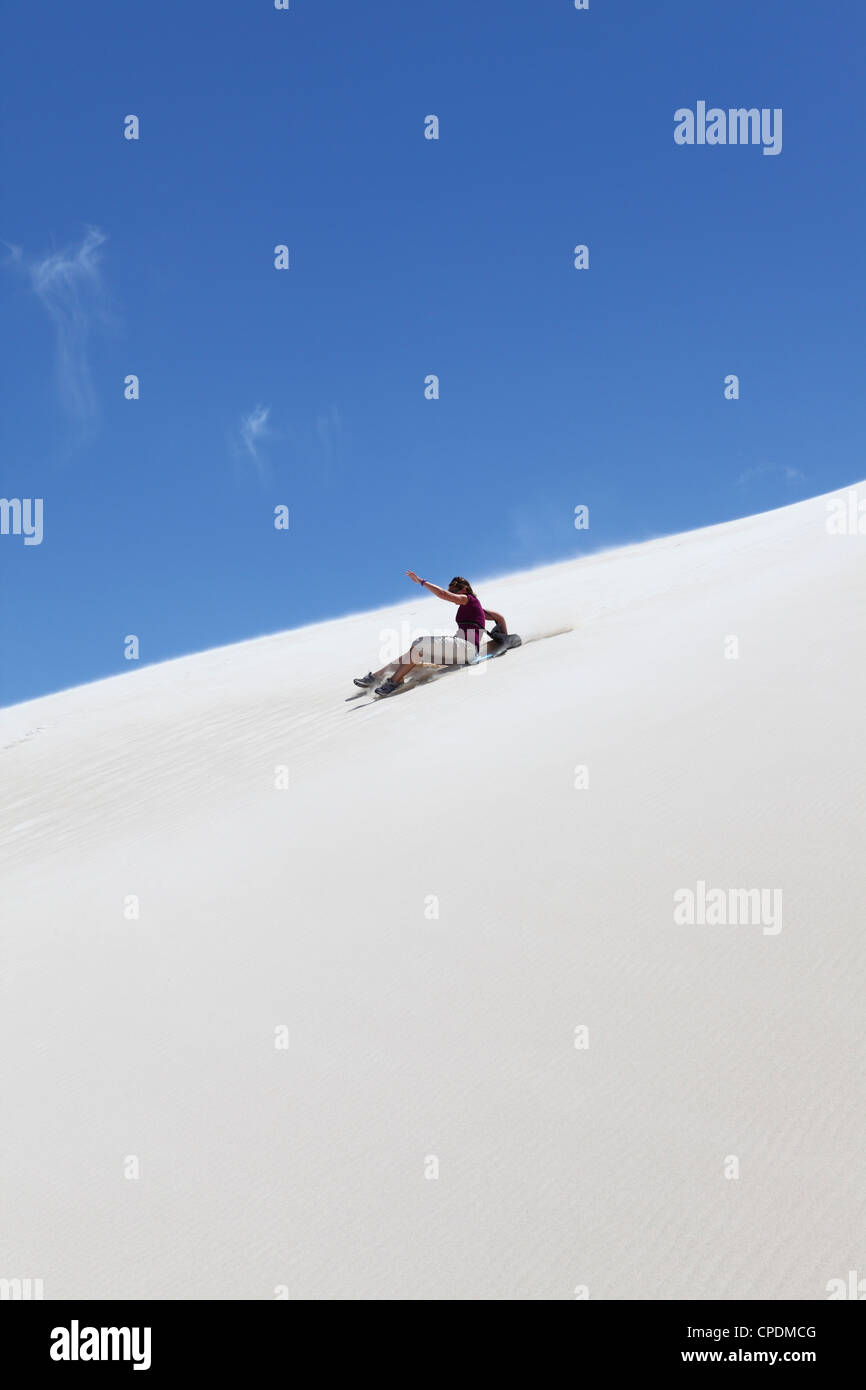 Una donna corse sandboard, sandboarding su un bianco dune di sabbia, Lancelin, Australia occidentale, Australia Pacific Foto Stock