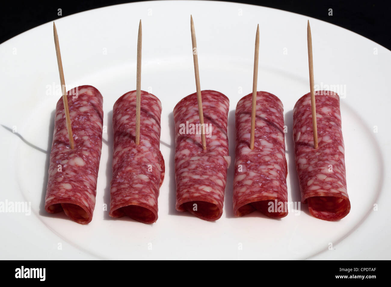 Fette di salame danese con bastoncini da cocktail Foto Stock