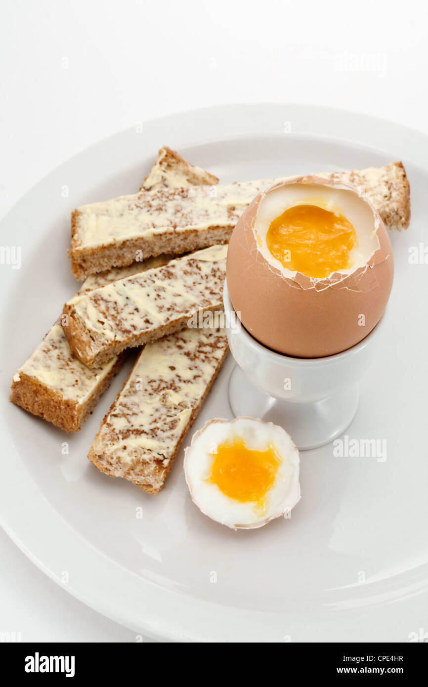 Un uova sode in un uovo bicchiere accompagnato da pane tostato dita o soldati Foto Stock