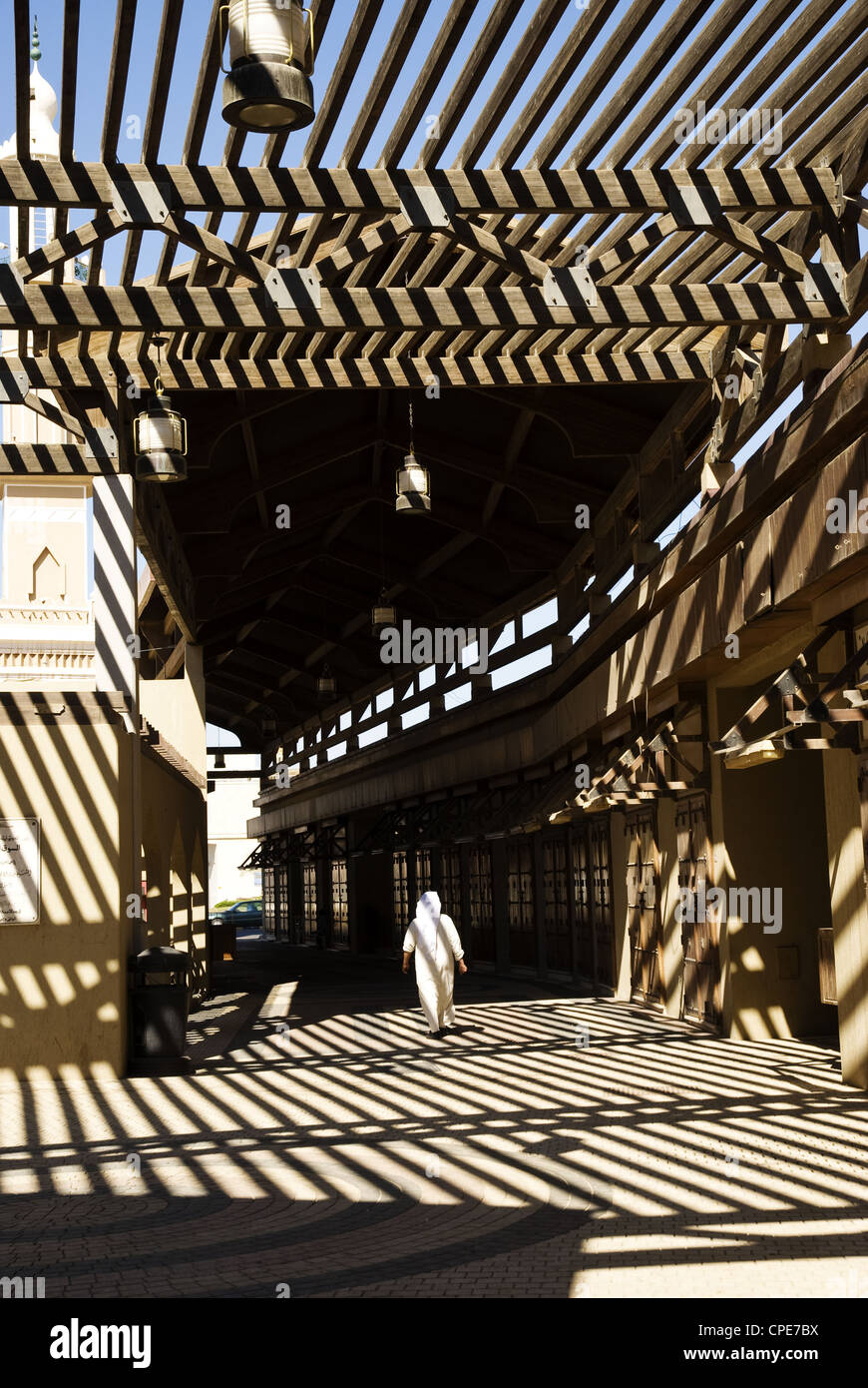 Un uomo vestito in un tradizionale dishdasha passeggiate un inizio di mattina in una parte di Souk Mubarakiya, Kuwait City, Kuwait Foto Stock