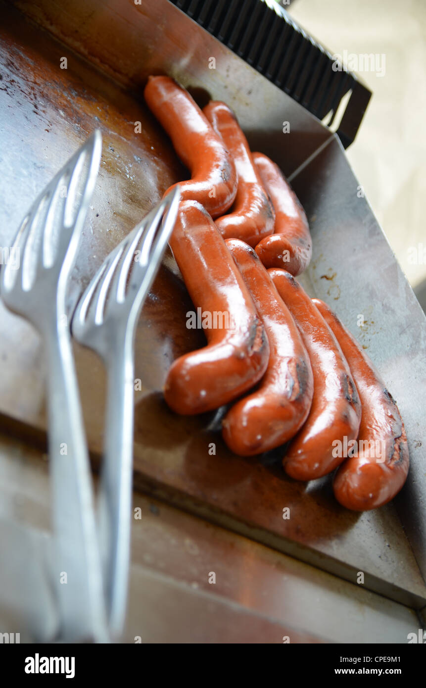 Hot Dog salsicce cottura su una piastra su un alimento in stallo Foto Stock