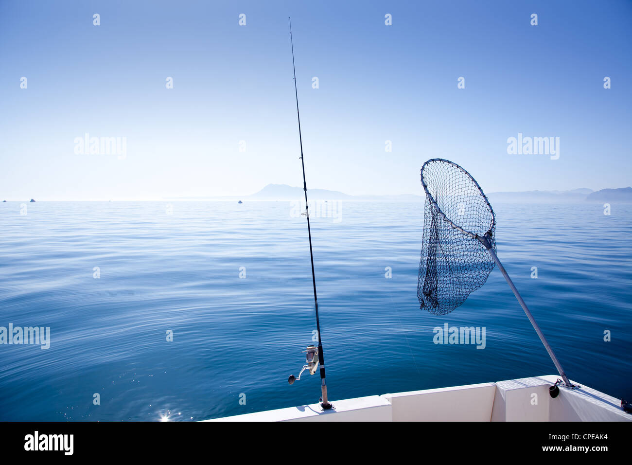 Barca da pesca asta e landing net nel mediterraneo mare blu Foto Stock
