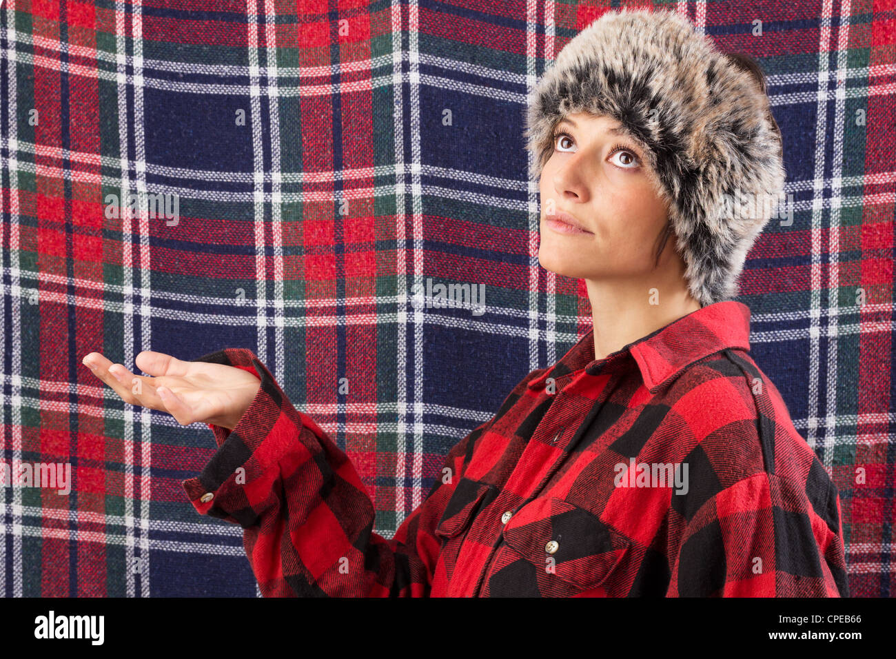 Giovane e bella donna che indossa maglietta lumberjack in posa come la visualizzazione di dummy. Funny studio shot contro un sfondo a scacchi Foto Stock