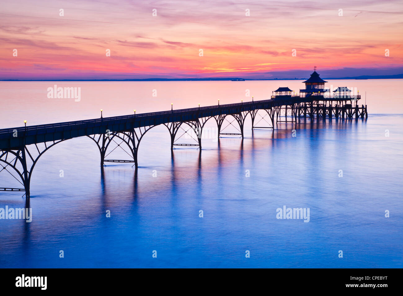 Il sole tramonta oltre il canale di Bristol dietro il molo di Clevedon, Somerset, Inghilterra, Regno Unito Foto Stock