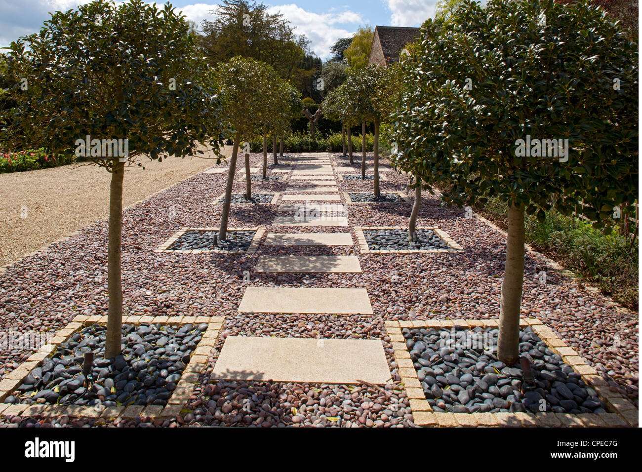 Holly alberata in lastra di pietra percorso con ardesia e ciottoli nel Giardino Inglese Foto Stock