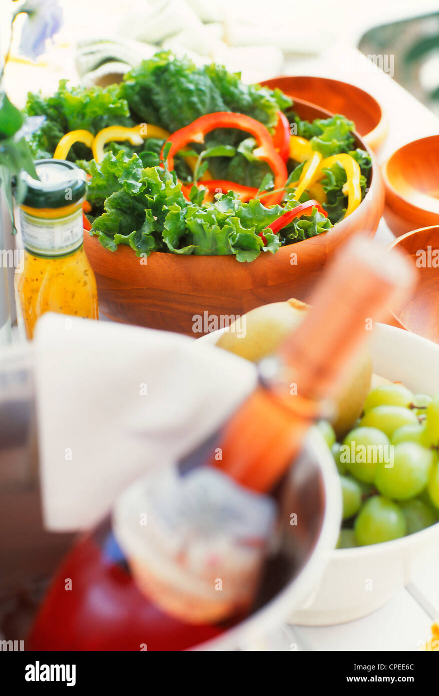 Insalata di frutta e bottiglia di vino sul tavolo Foto Stock