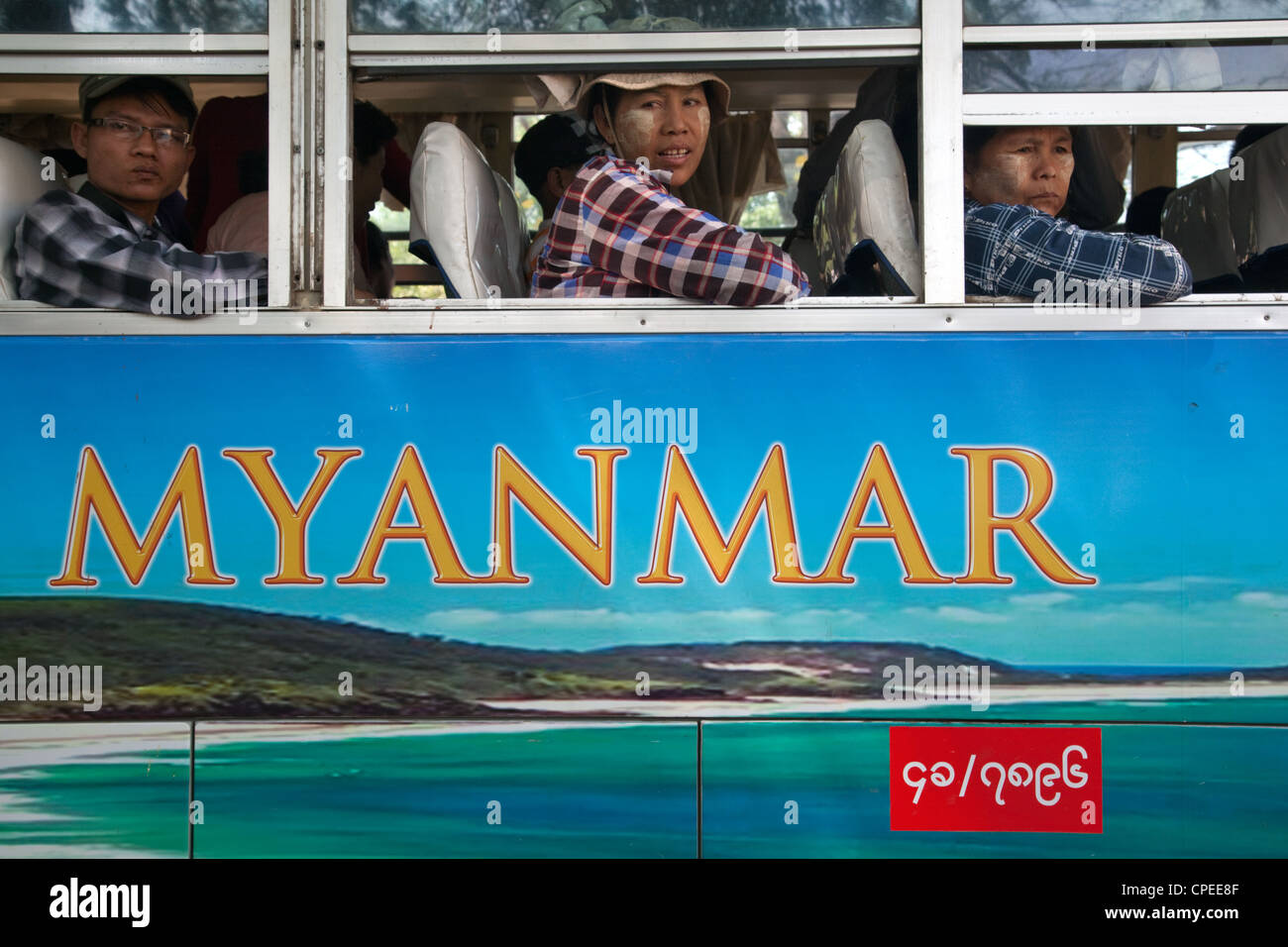 Popolo birmano sul bus con il Myanmar testo scritto sul lato. Nyaung U, Myanmar (Birmania) Foto Stock