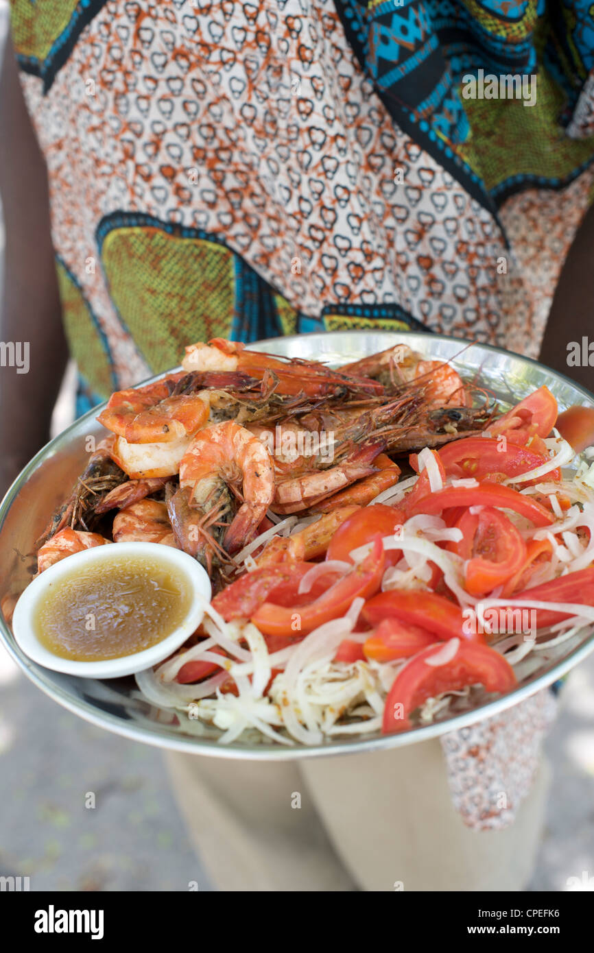 Cameriere con la piastra del cibo sulla Mogundula isola nell'arcipelago Quirimbas nel Mozambico settentrionale. Foto Stock