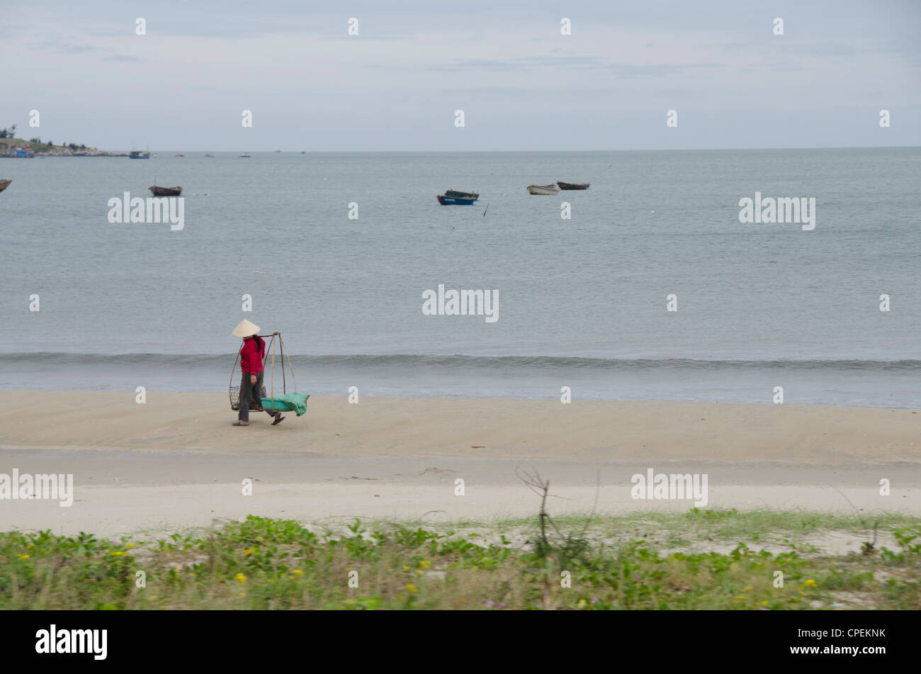 Il Vietnam, da nang. bac mio una zona spiaggia. donna locale nel tradizionale cappello conico. Foto Stock