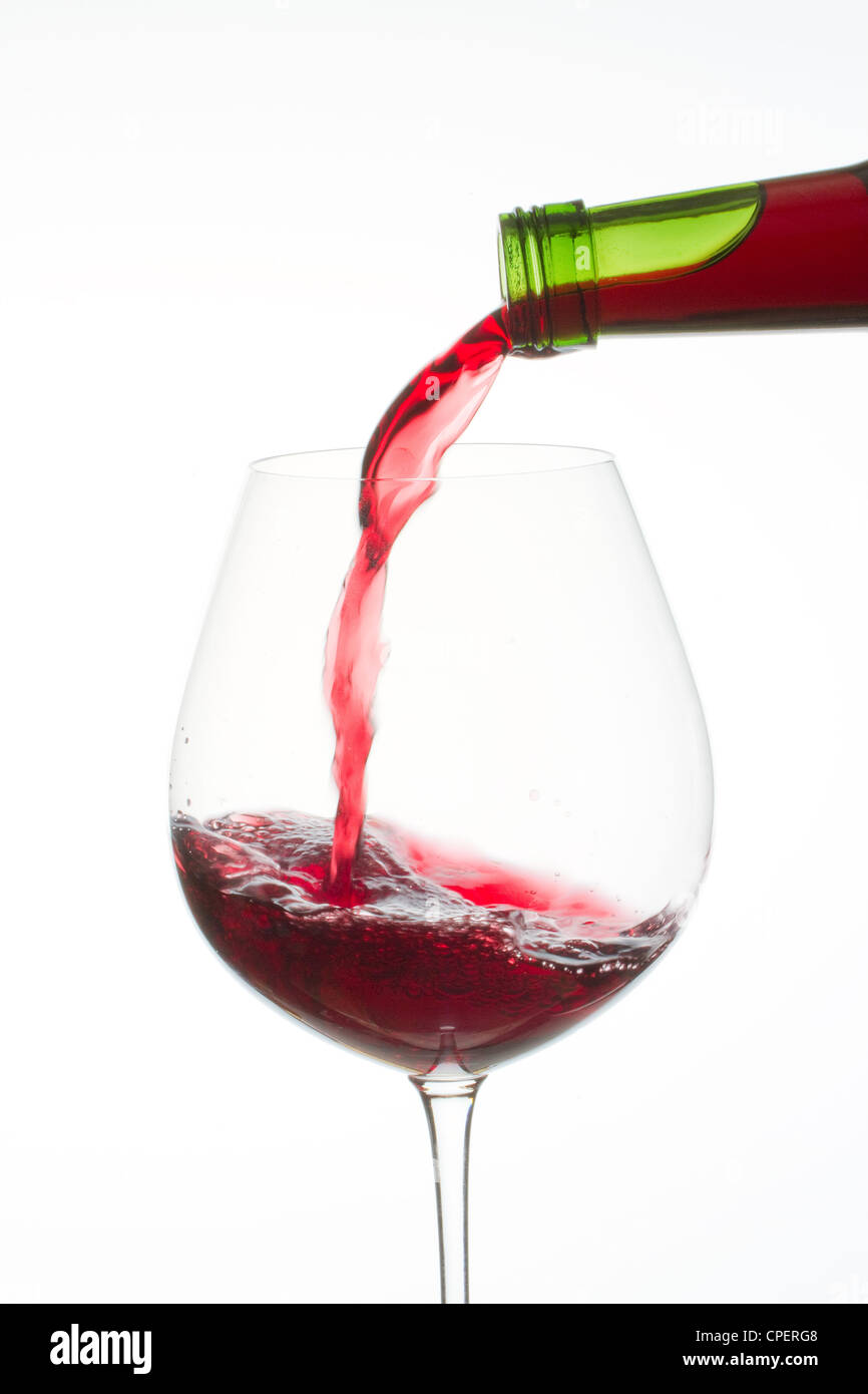 Vino rosso versando in vetro Foto Stock