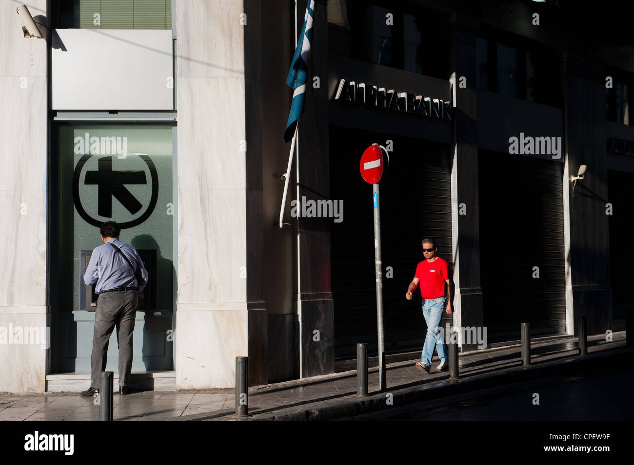 Persone che passano da Alpha Bank in Mitropoleos Str, Atene, Grecia Foto Stock