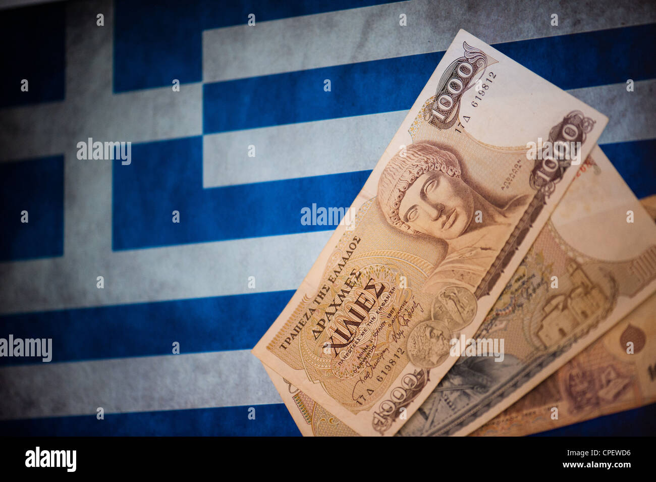 Vecchia dracma greca note sostituita nel 2002 dall'euro davanti alla bandiera greca Foto Stock
