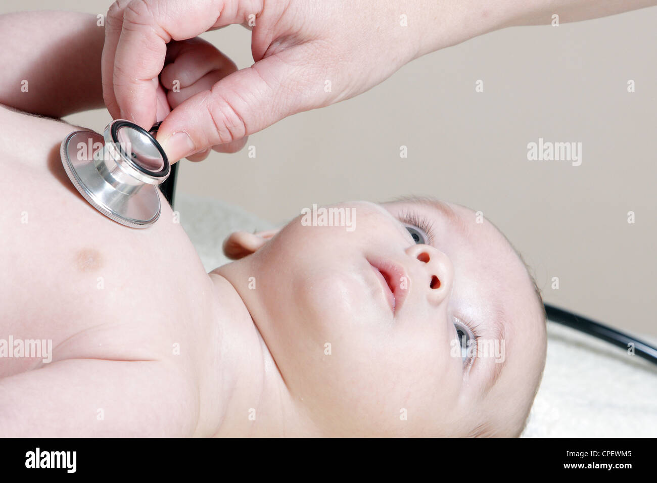 Uno stetoscopio in ascolto ad un bambino del battito cardiaco Foto Stock