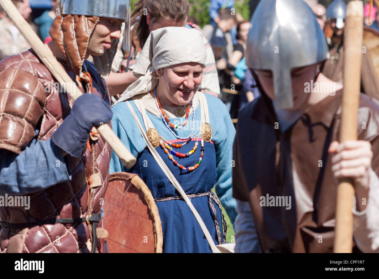 Una donna in abito tradizionale di uomini armati Foto Stock
