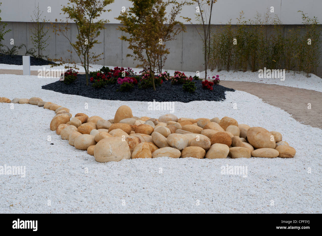 Regime moderno di giardino pubblico area utilizzando grandi ciottoli ghiaia moderni posti a sedere in maniera artistica Foto Stock