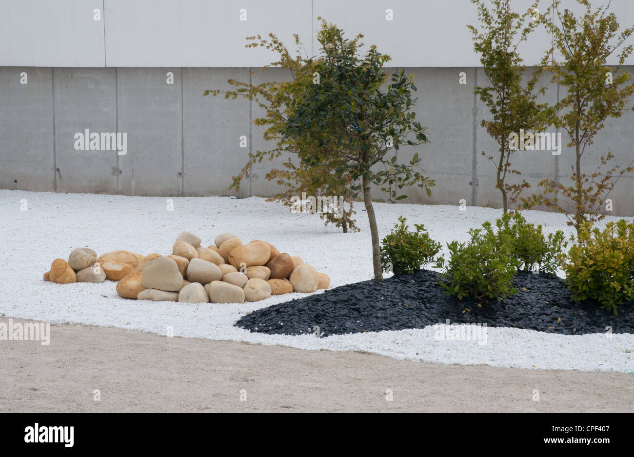 Regime moderno di giardino pubblico area utilizzando grandi ciottoli ghiaia moderni posti a sedere in maniera artistica Foto Stock