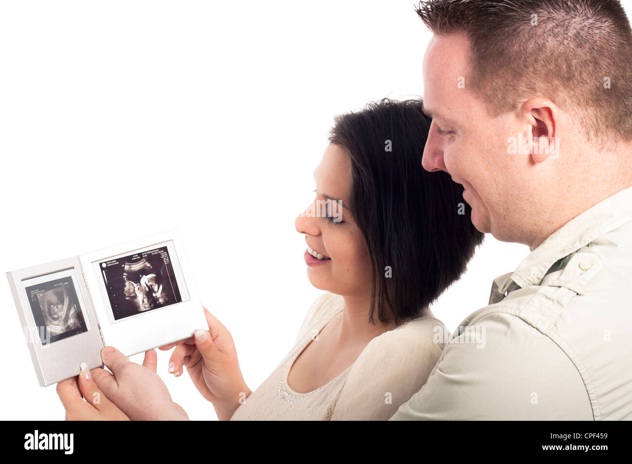 Gravidanza felice coppia in cerca di immagini ad ultrasuoni della baby, isolati su sfondo bianco. Foto Stock
