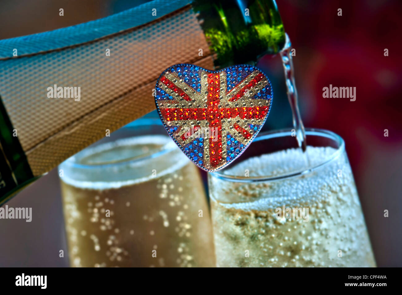 SPUMANTE BRITANNICO con motivo Union Jack Flag a forma di cuore con bicchieri in bottiglia di spumante INGLESE dietro il Regno Unito Foto Stock