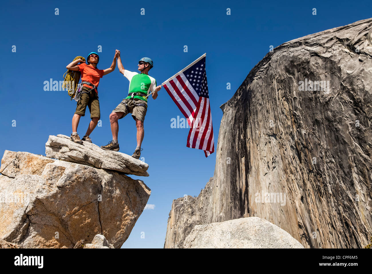 Gli alpinisti onda a bandiera sul vertice dopo una impegnativa salita. Foto Stock