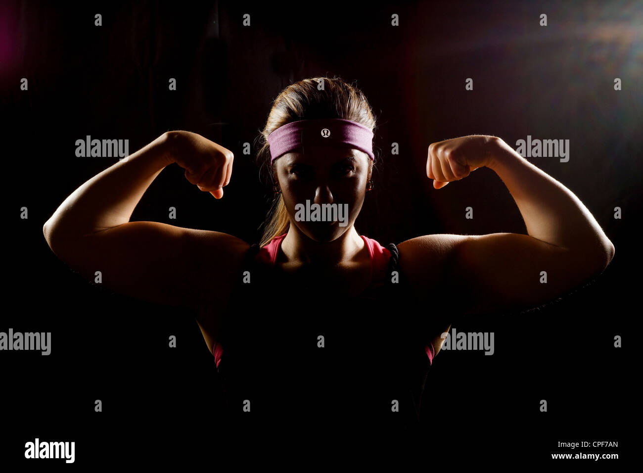 Un bodybuilder femminile si flette i suoi muscoli. Foto Stock