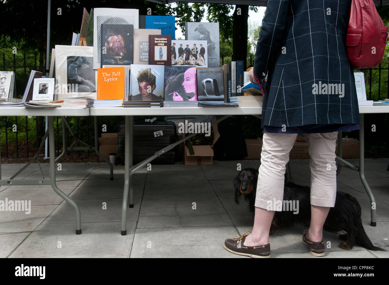 Goldsmith fila Hackney. Domenica mattina il mercato librario. Donna con bassotto guardando libri Foto Stock