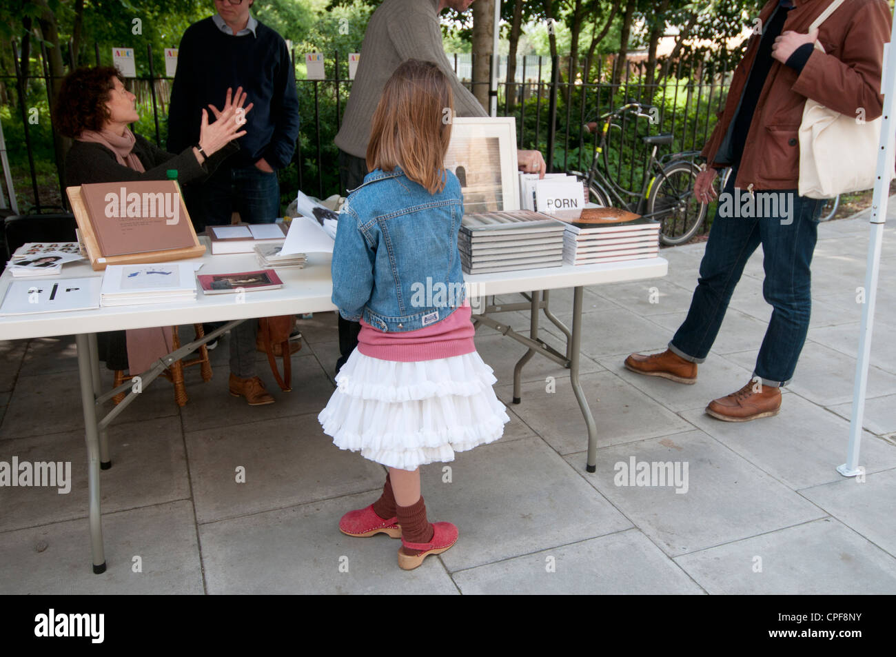 Goldsmith fila Hackney. Domenica mattina il mercato librario.giovane ragazza guardando alla pressione di stallo Foto Stock