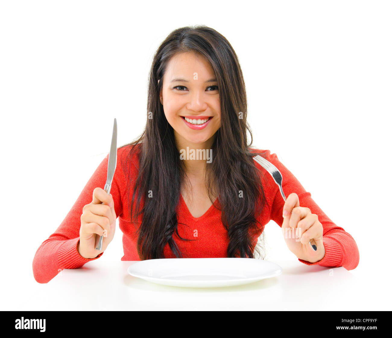 Razza mista donna asiatica holding forchetta e coltello con una piastra a vuoto pronto per il cibo, isolati su sfondo bianco Foto Stock