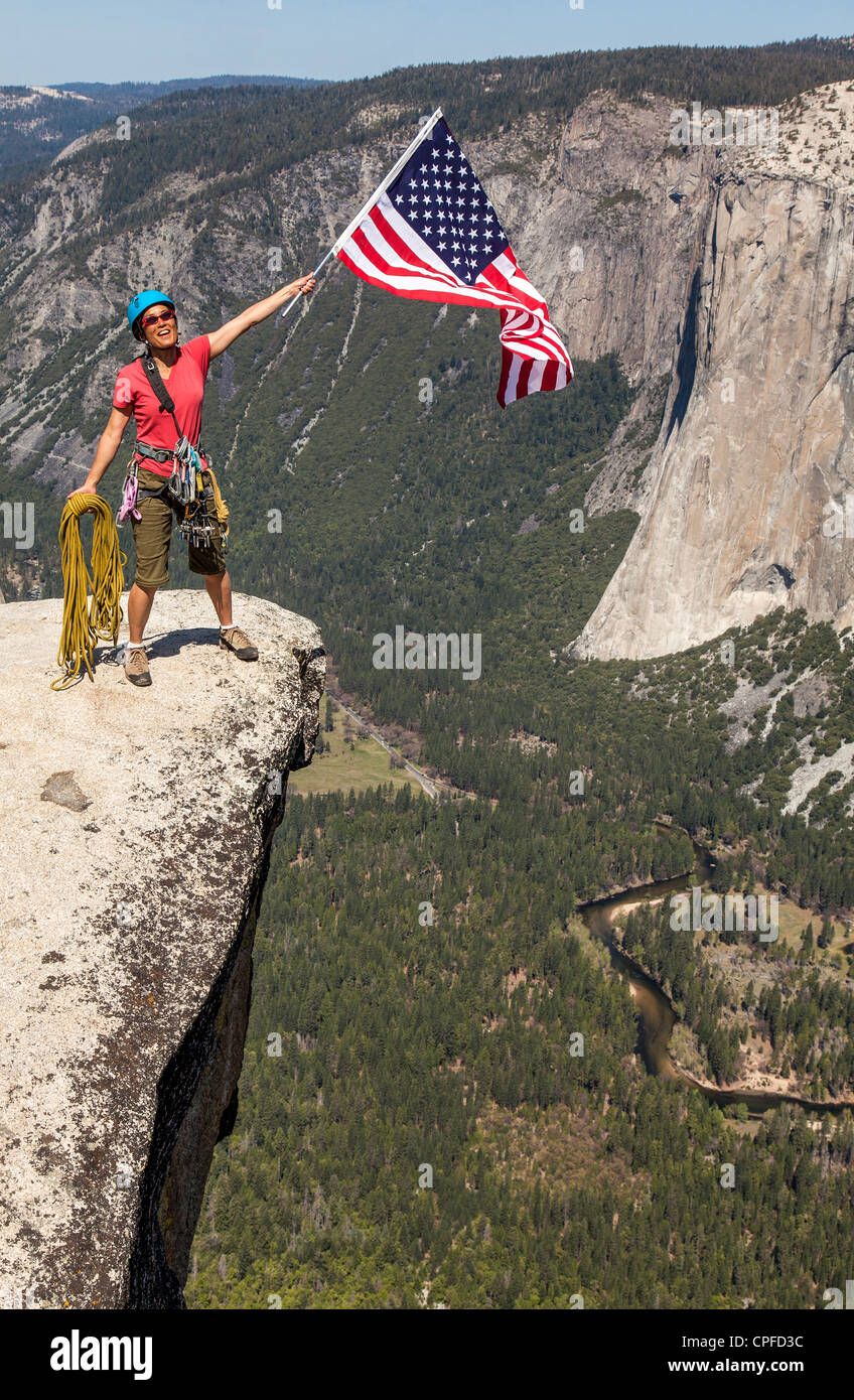 Scalatore onde una bandiera americana sul vertice. Foto Stock