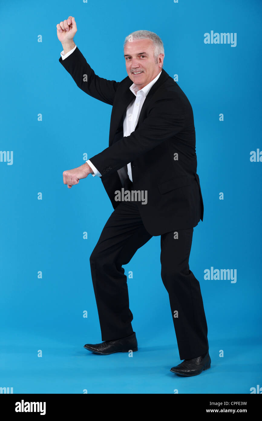Imprenditore Senior fingendo di giri a cavallo Foto Stock