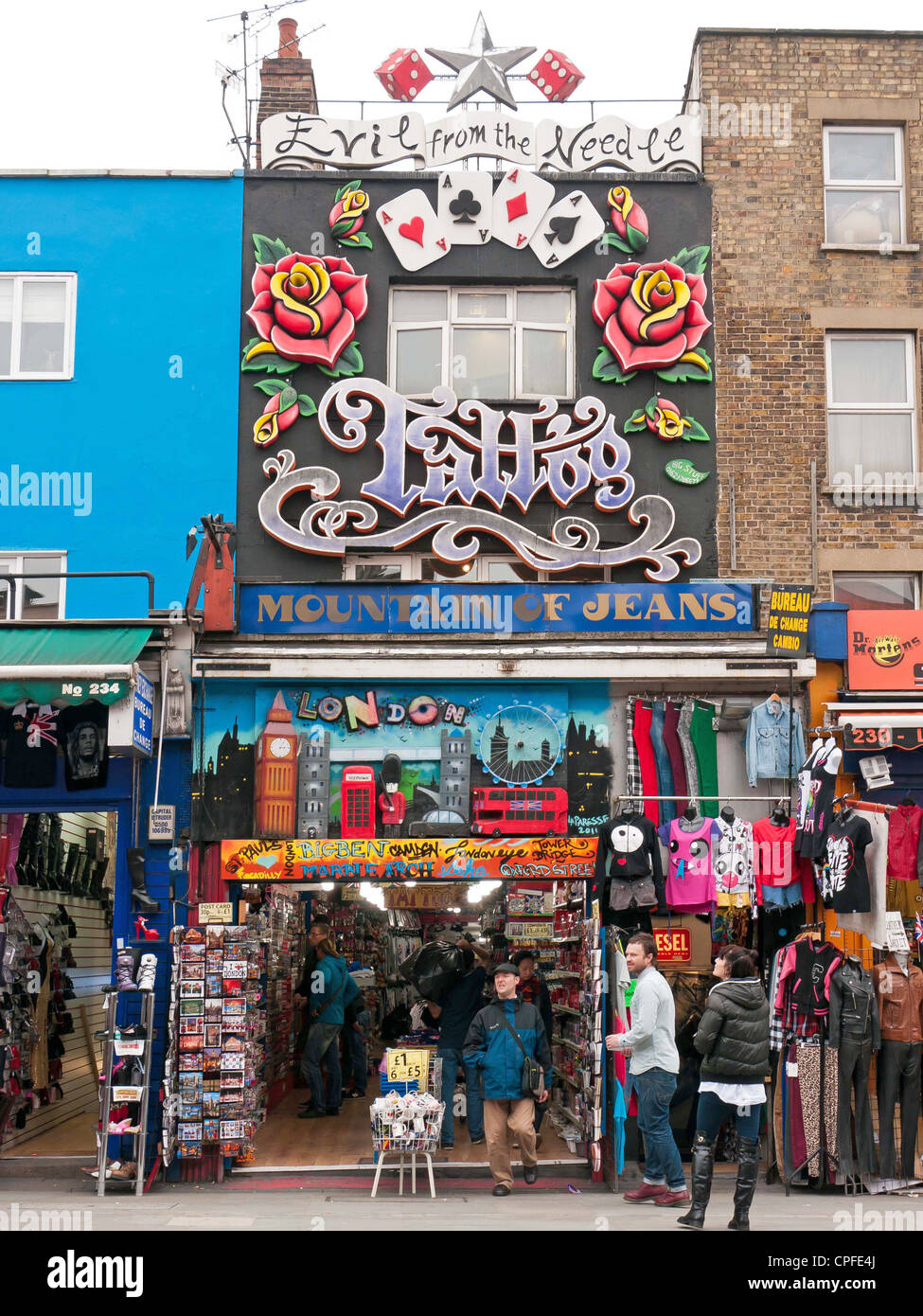Gli amanti dello shopping e ai turisti la visualizzazione di un utique e salotto tattoo in una strada nel mercato di Camden, London, Regno Unito Foto Stock