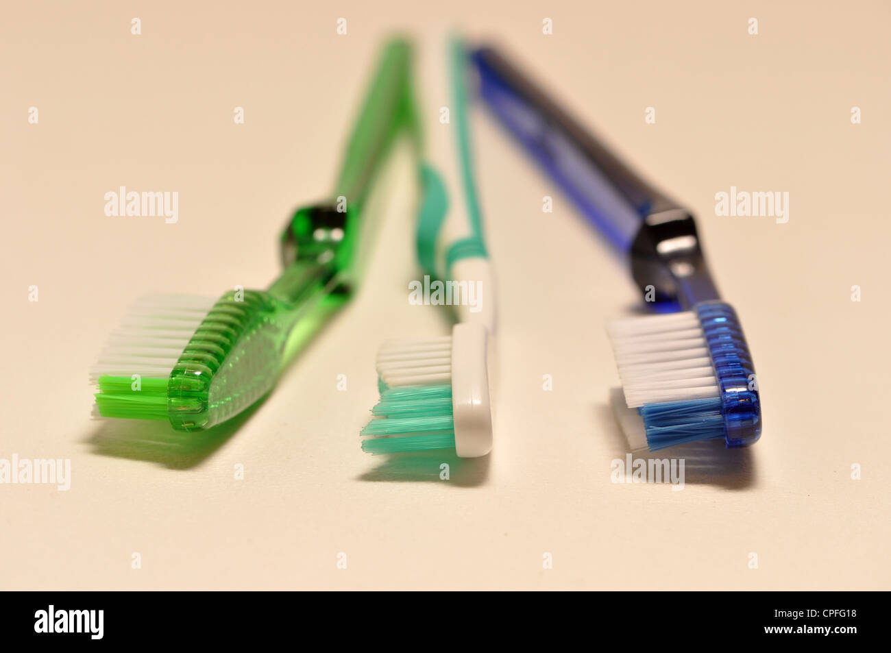 Tre spazzolini da denti su uno sfondo bianco. Foto Stock
