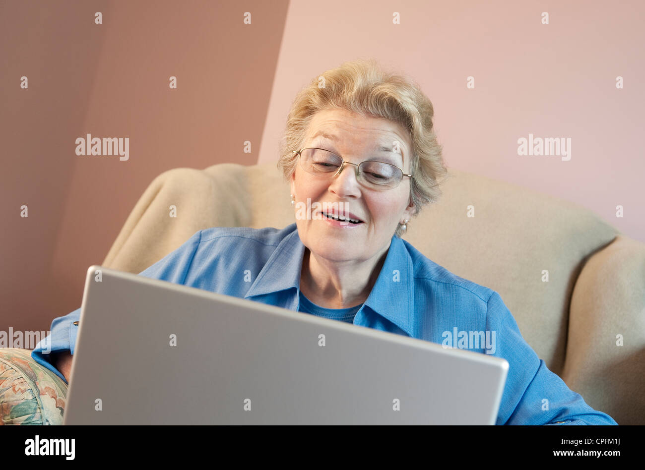 Donna matura utilizzando laptop e sorridente Foto Stock