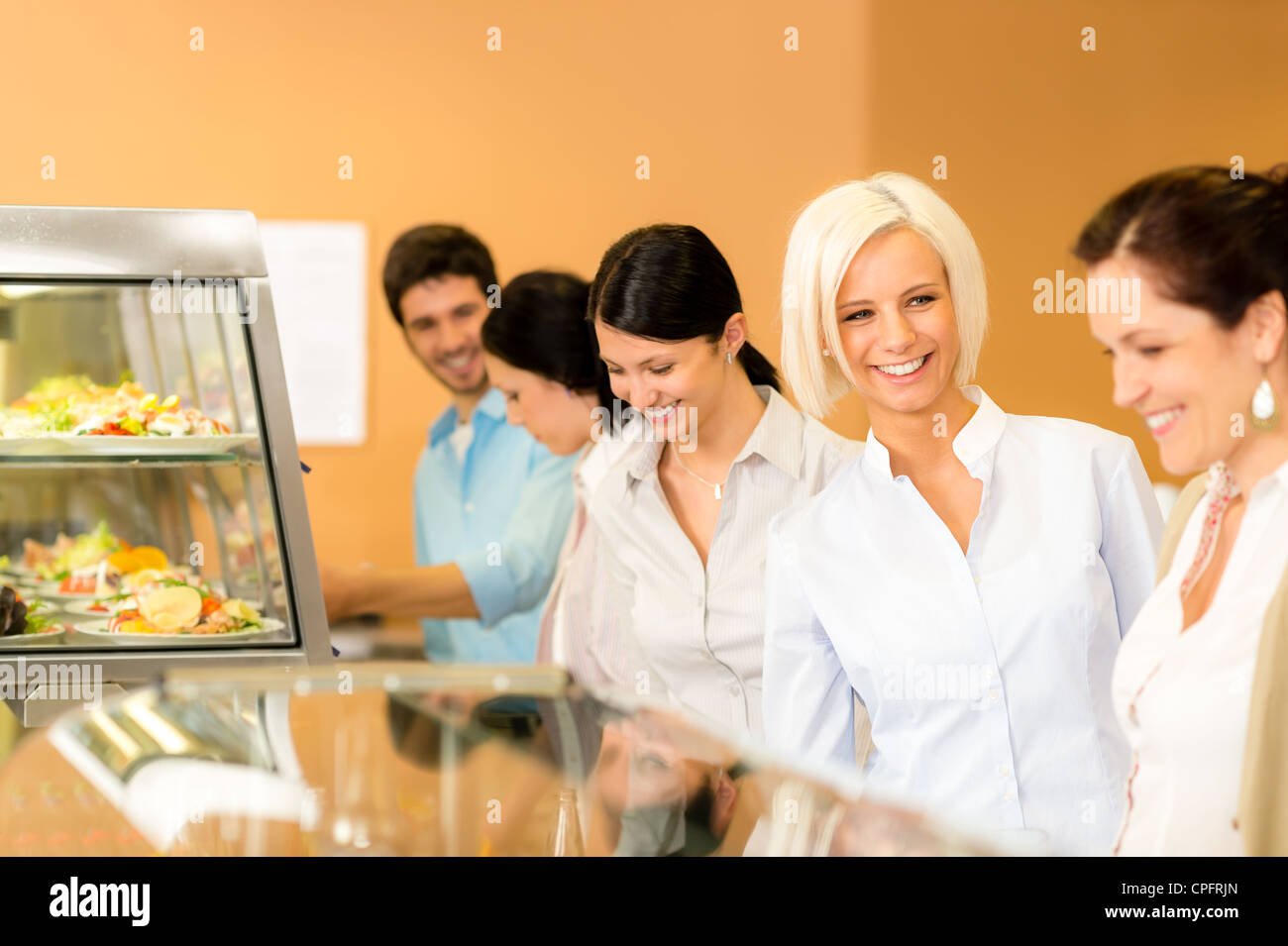 Business donna prendere caffetteria pranzo sorridente scegliere dal buffet self-service Foto Stock