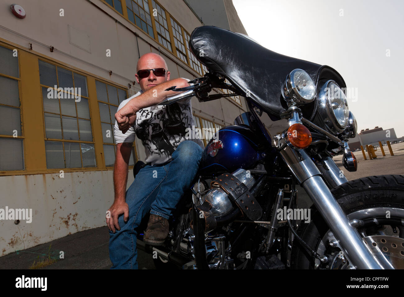 Una Harley Davidson motociclista seduto sulla sua moto Foto Stock