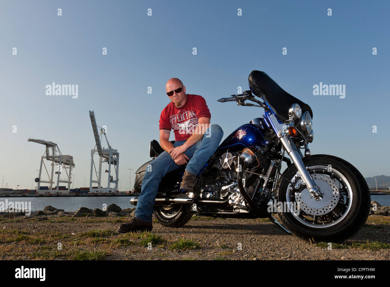 Una Harley Davidson motociclista seduto sulla sua moto Foto Stock