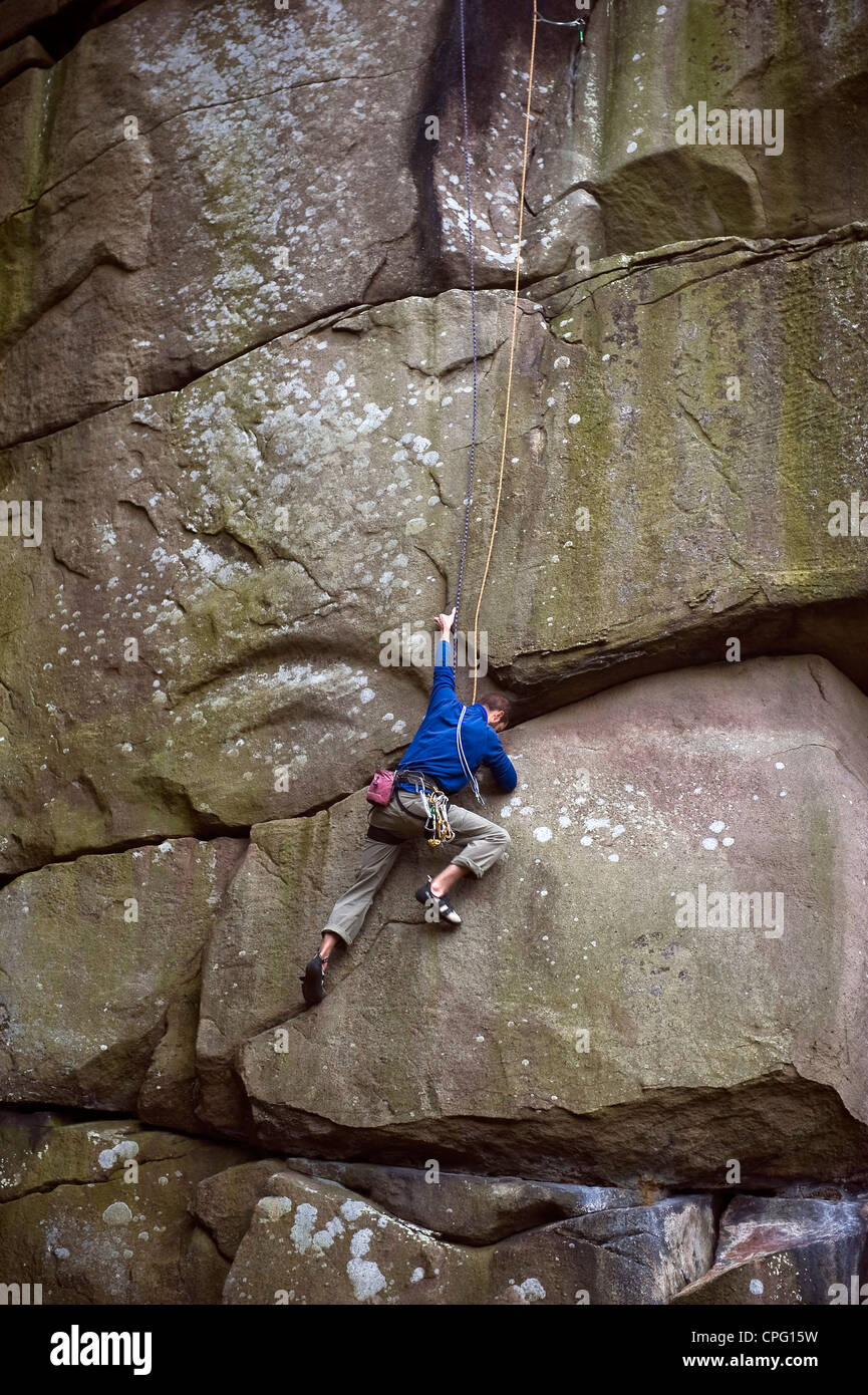 Rocciatore sul crack a Cratcliffe rocce del Peak District, Derbyshire, Regno Unito Foto Stock