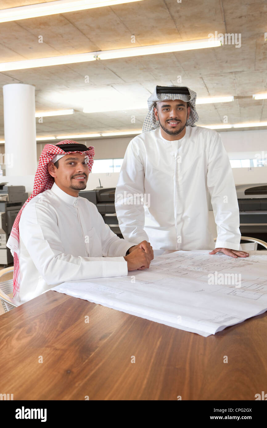Due uomini di affari arabi discutendo su blueprint. Foto Stock