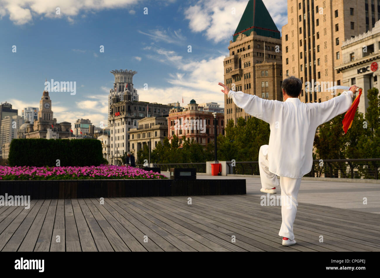 Uomo in bianco con tai chi spada esercita sul bund all'alba a Shanghai in Cina Foto Stock