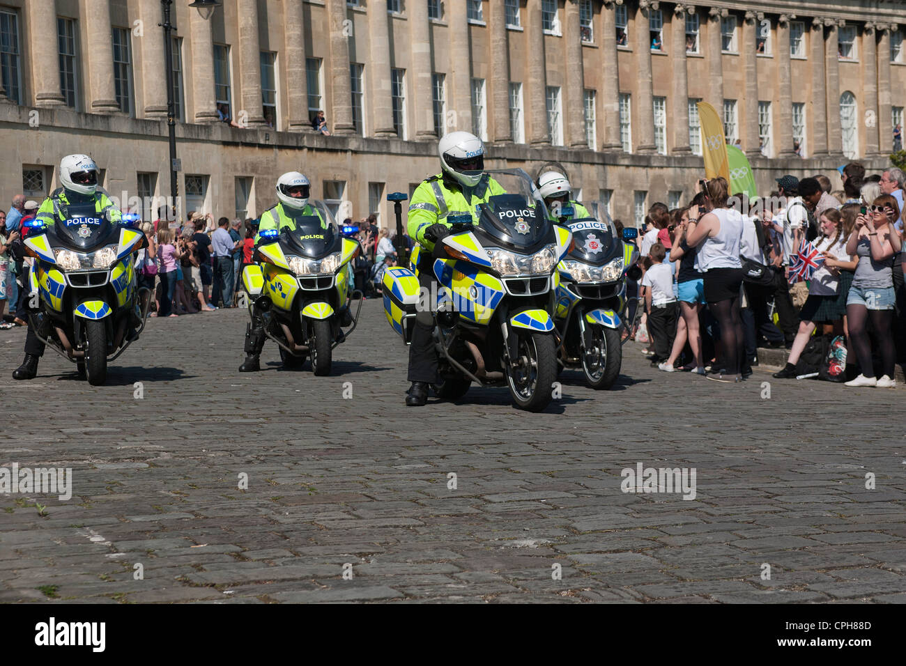 La Metropolitan Police i motociclisti fornire una scorta per il 2012 torcia olimpica quando esso passa attraverso la città di Bath. Foto Stock