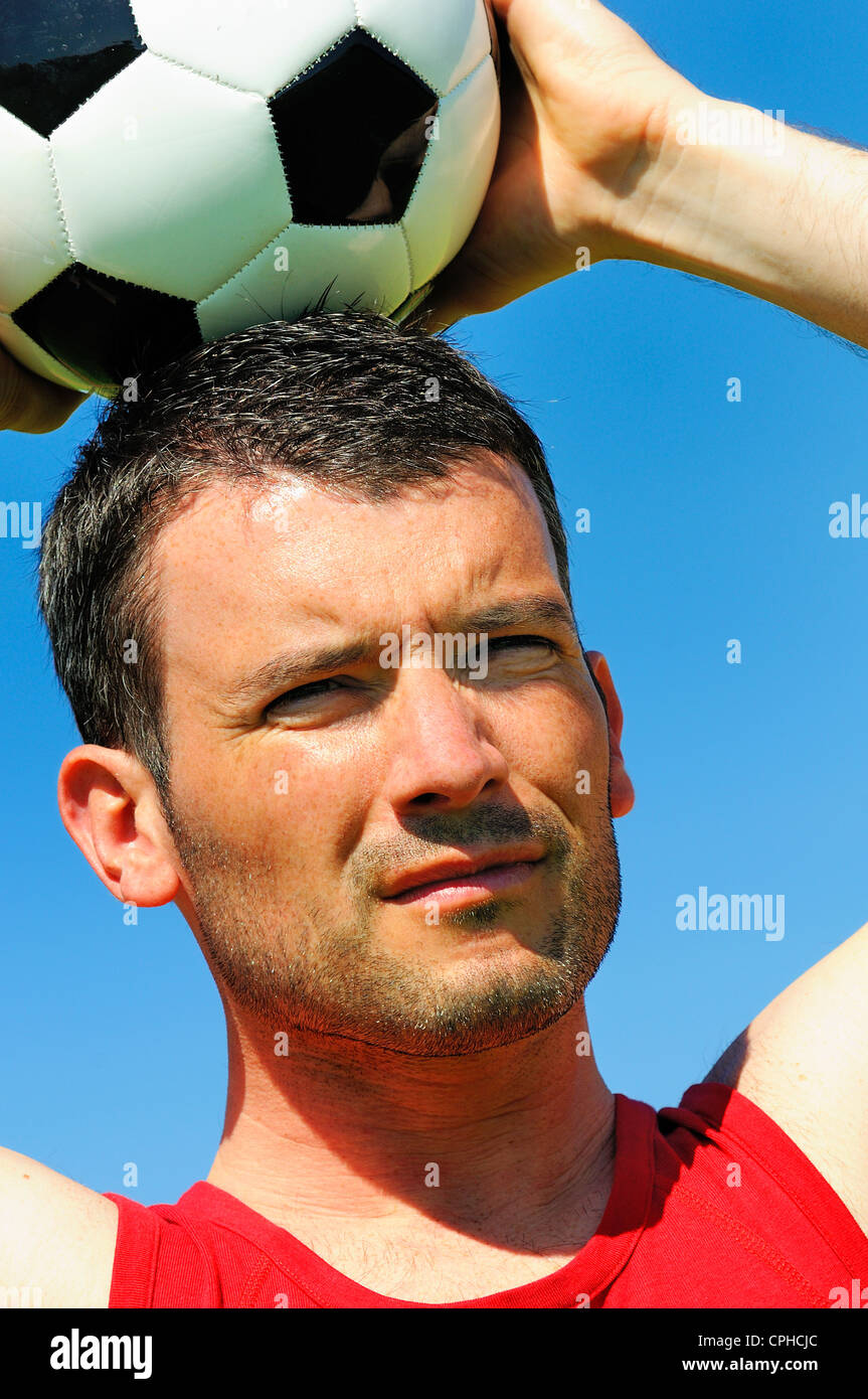 Attraente giocatore di football di bianco e nero con palloncino Foto Stock