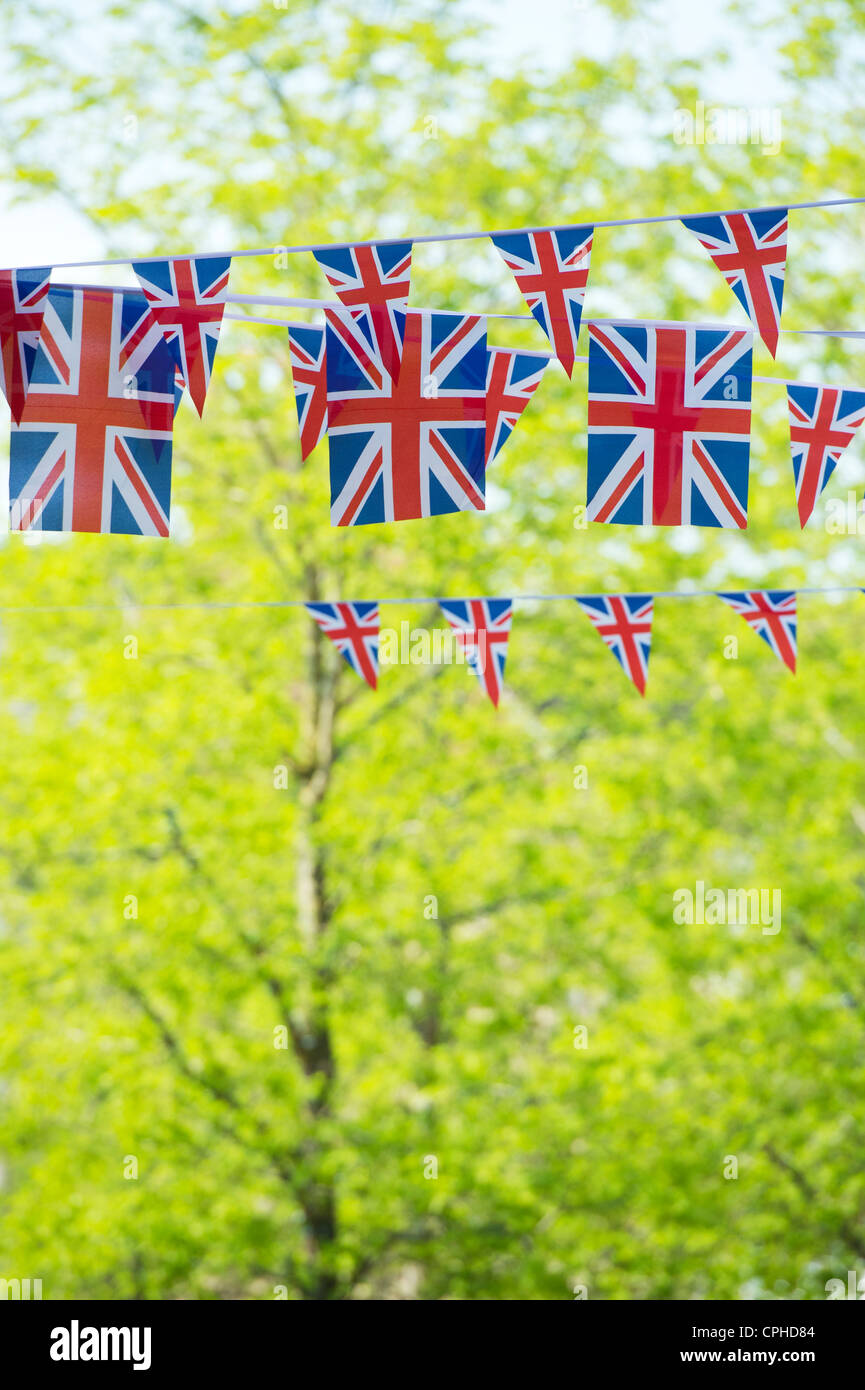 Union Jack flag bunting di fronte alberi soleggiato Foto Stock