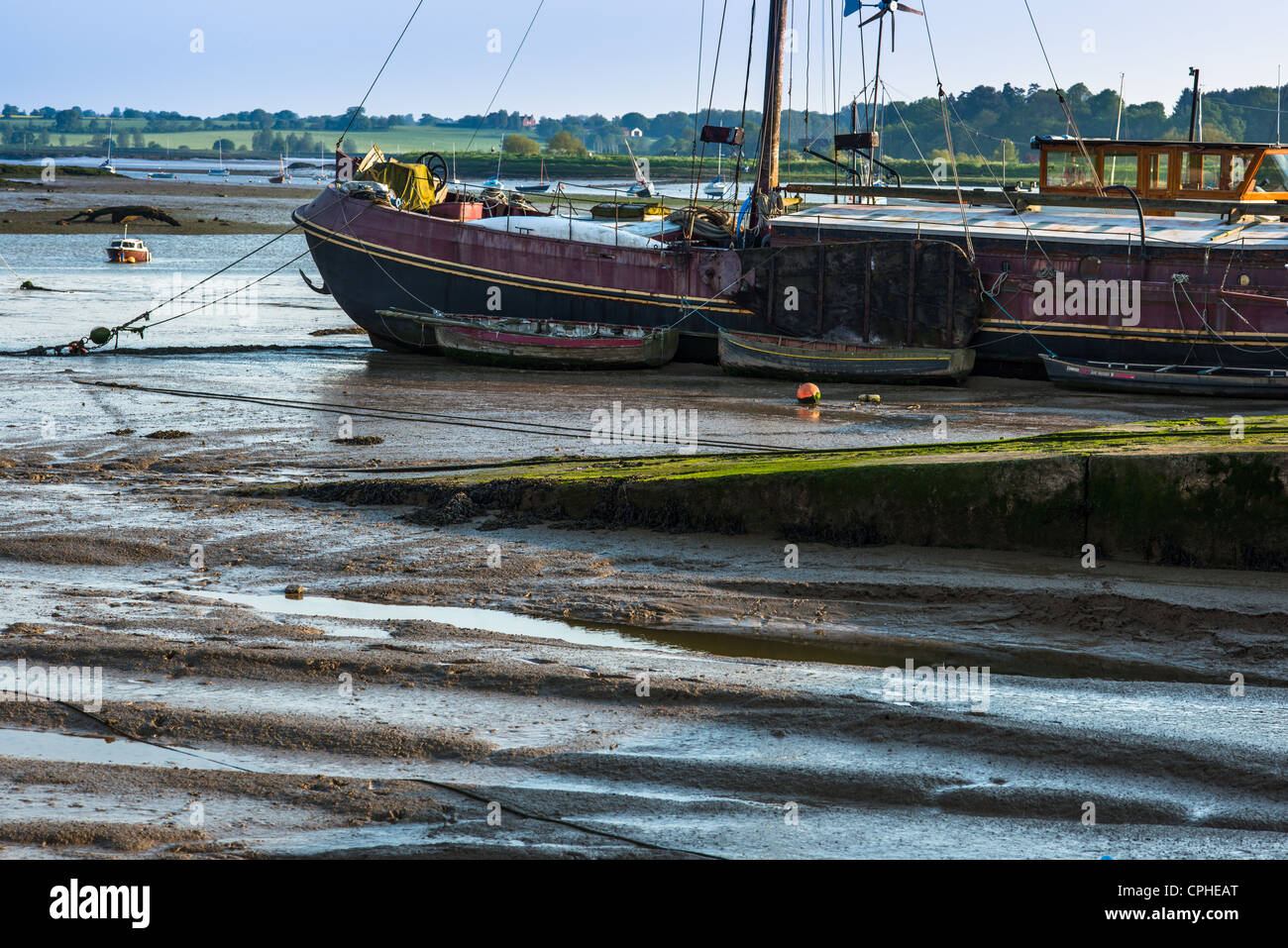 Barche in fango a bassa marea sul fiume Deben estuario a Woodbridge, Suffolk, Regno Unito. Foto Stock