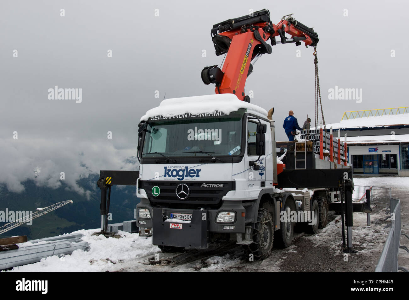 Un autocarro con catene da neve per somministrare a un sito di costruzione nelle Alpi austriache Foto Stock