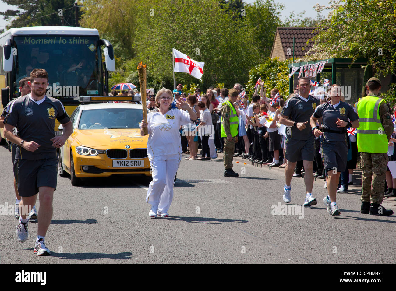 Torcia olimpica portatore Elizabeth Pickworth scorre attraverso il villaggio di Southwick vicino Trowbridge, Wiltshire il 22 maggio 2012 . Foto Stock