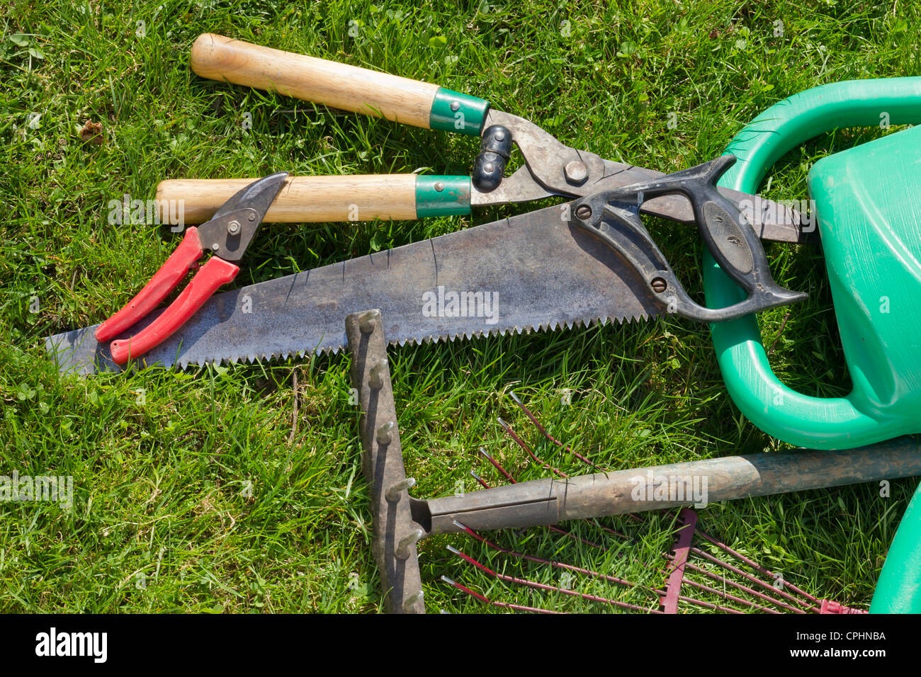 Usato ​​old attrezzi da giardino sono a molla verde prato. Giornata di sole Foto Stock