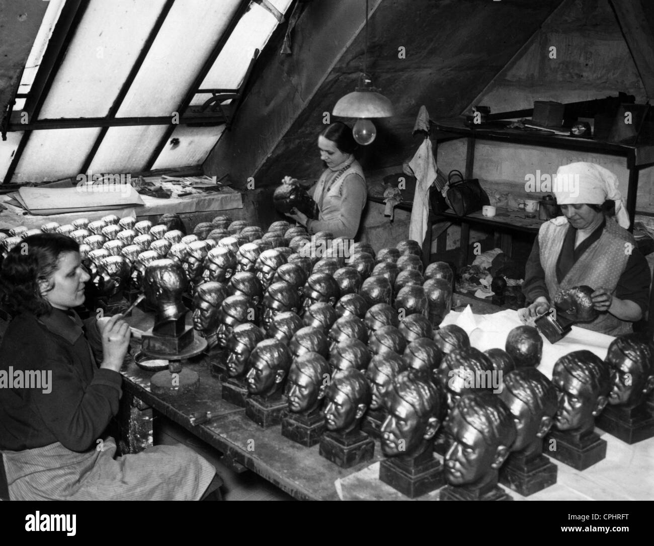 I lavoratori di sesso femminile con pietra in ghisa busti di Adolf Hitler, 1937 Foto Stock