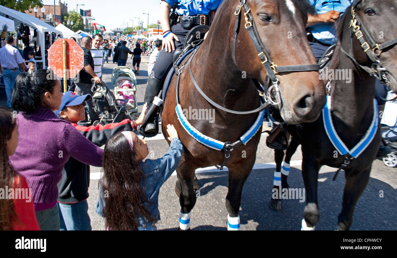 Pattuglia di polizia cavalli essendo petted dal messicano i ragazzi americani. Il giorno dell indipendenza messicana Minneapolis Minnesota MN USA Foto Stock