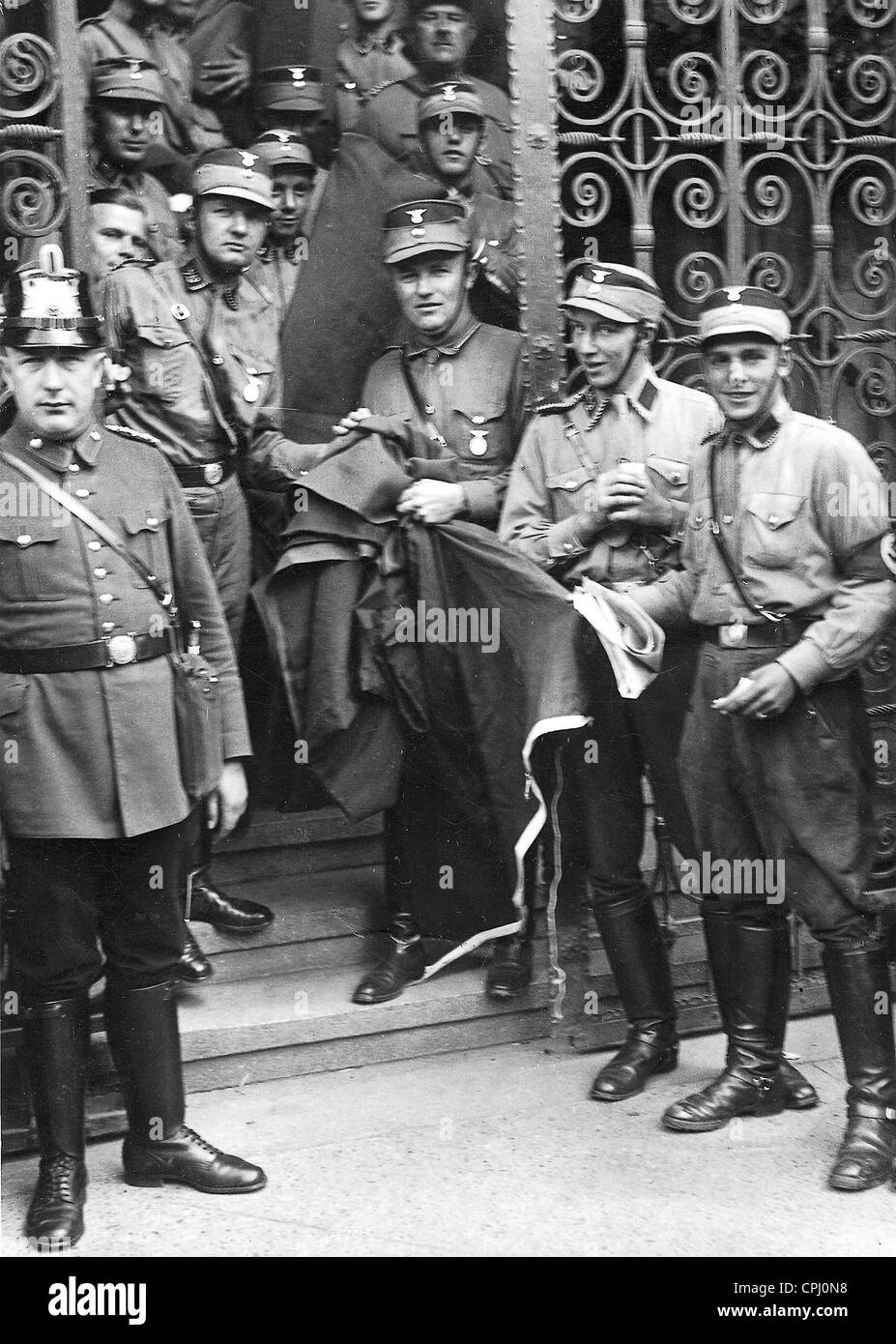 SA stormtroopers stand sui gradini della occupata Neukoelln municipio sistemando il nero rosso e oro bandiera di Weimar Foto Stock