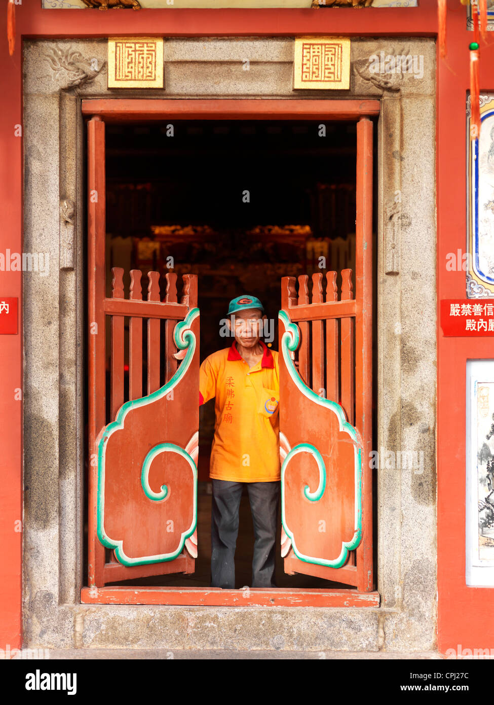 Un vecchio custode apre le porte a un Johor vecchio tempio Cinese a Johor Bahru Foto Stock