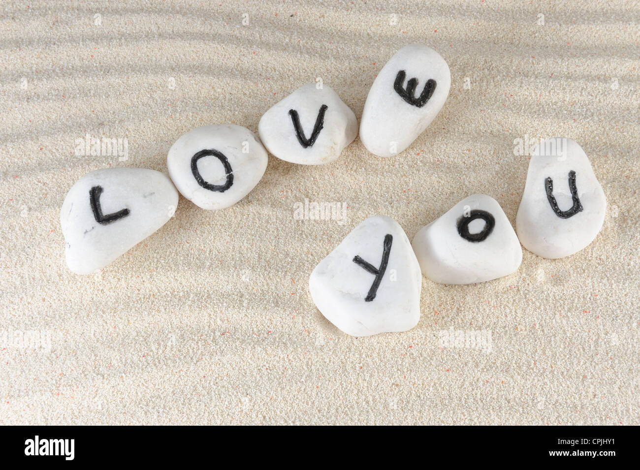 Ti amo parole sul gruppo di pietre con sabbia come sfondo Foto Stock
